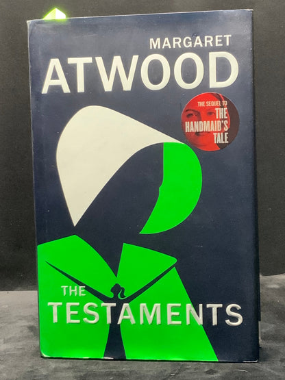 Book cover of 'The Testaments' by Margaret Atwood on a dark surface
