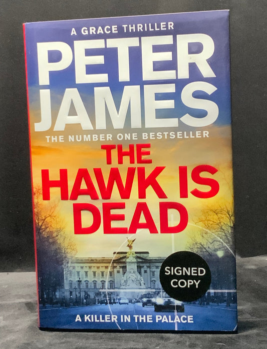 Book titled 'The Hawk is Dead' by Peter James with a signed copy label on a dark background