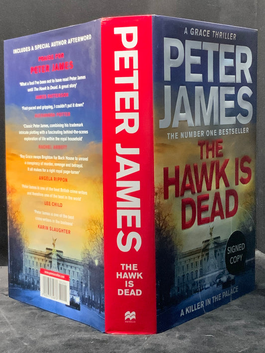 Book titled 'The Hawk is Dead' by Peter James with a signed copy label on a dark background